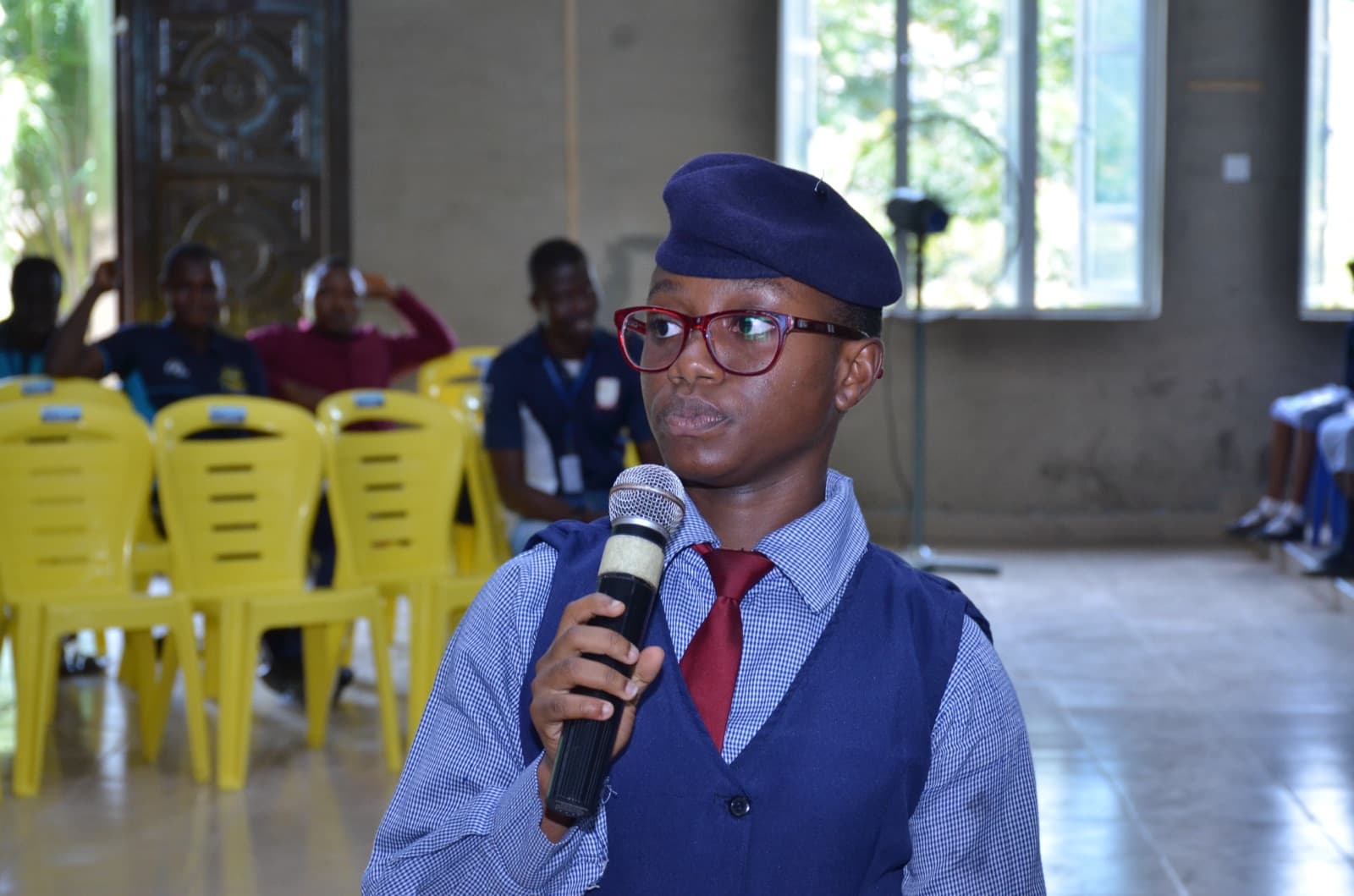 A student speaking into a microphone at Best Legacy International Secondary School, 2019.