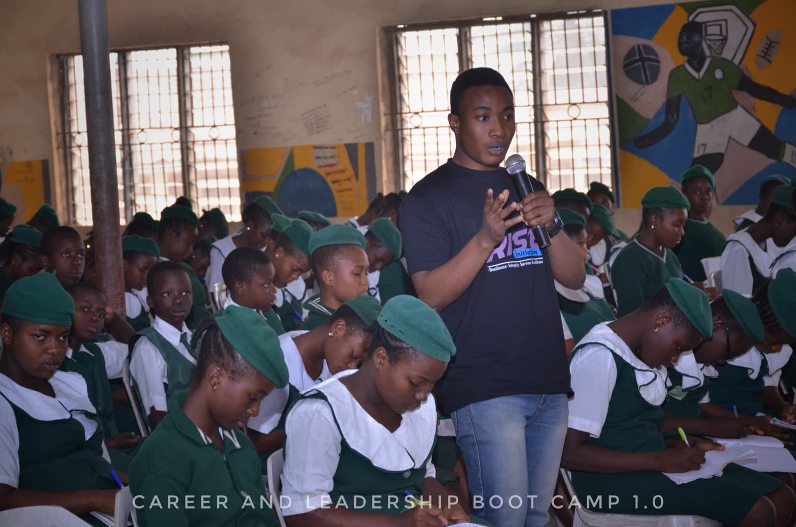 A facilitator leading a session at the front of the hall, SPED International Secondary School, 2019.