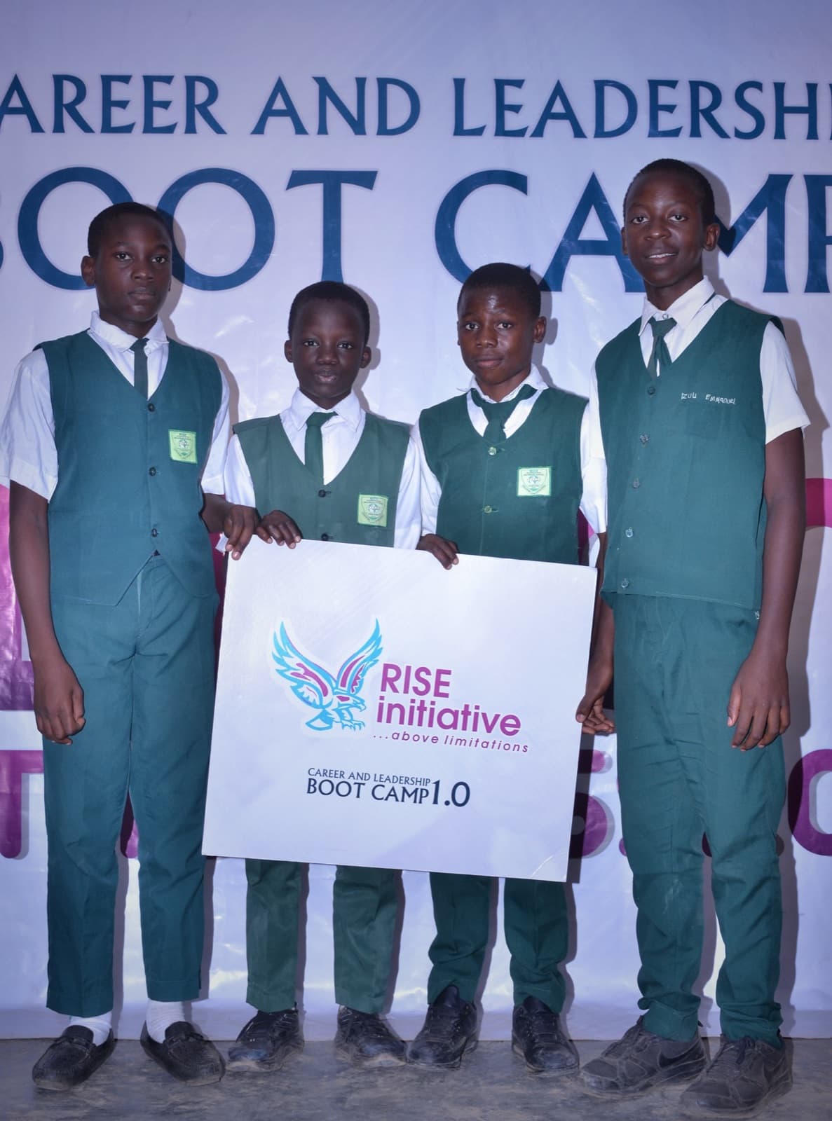 Students smiling with a RISE Initiative sign at SPED International Secondary School, 2019.